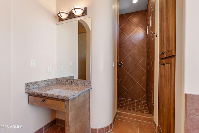 bathroom featuring vanity, tiled shower, and tile patterned floors