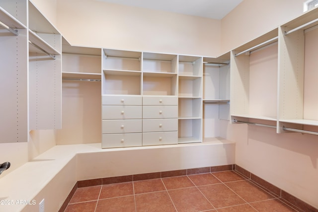 spacious closet with dark tile patterned floors