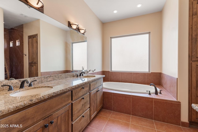 full bath featuring double vanity, a garden tub, a sink, and tile patterned floors