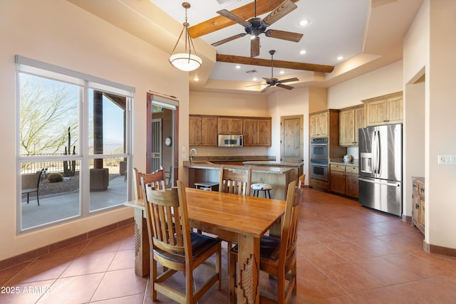 tiled dining space with baseboards, a high ceiling, a tray ceiling, a sink, and recessed lighting