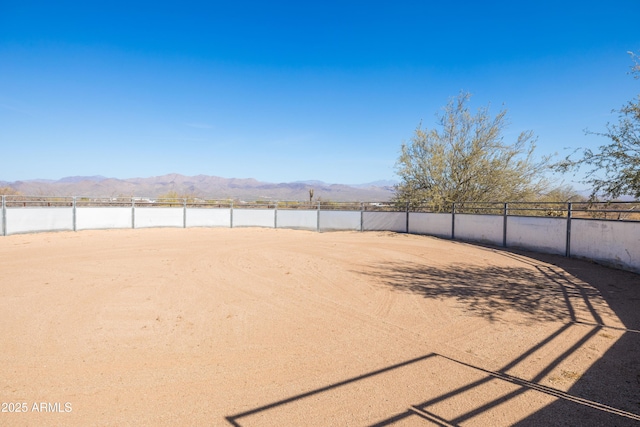 view of yard featuring fence and a mountain view