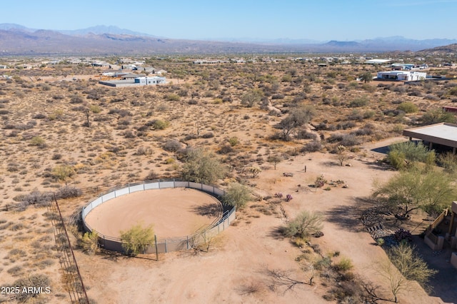 drone / aerial view featuring a mountain view and a desert view