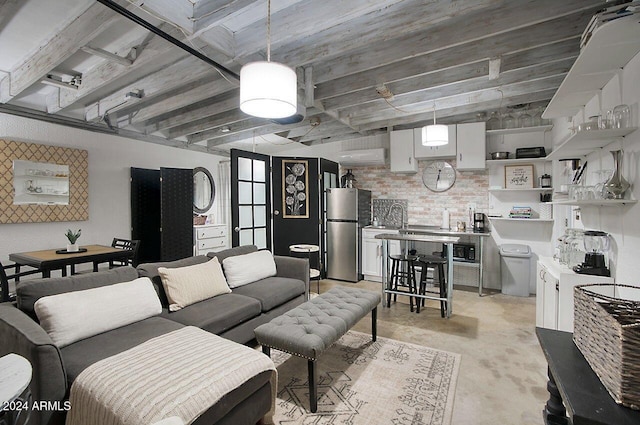 living room featuring a healthy amount of sunlight, sink, and brick wall