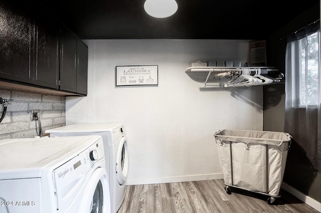 washroom with cabinets, independent washer and dryer, and light wood-type flooring