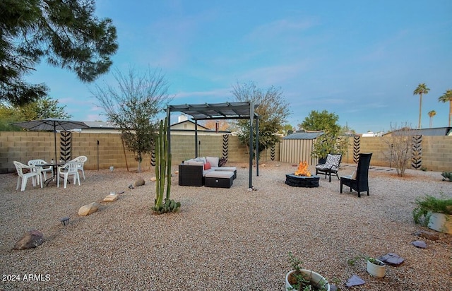 view of yard with a pergola, a fire pit, and a shed