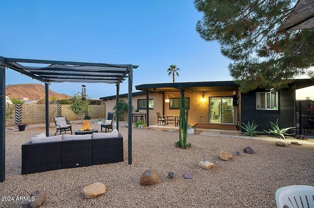 view of front of home with a mountain view, a pergola, an outdoor fire pit, and a patio area