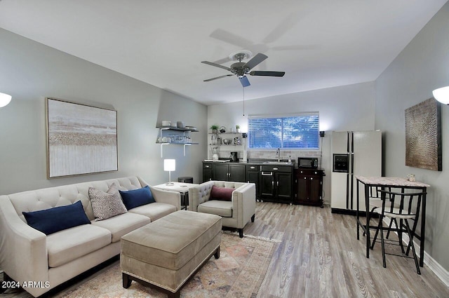 living room with ceiling fan, sink, and light hardwood / wood-style flooring