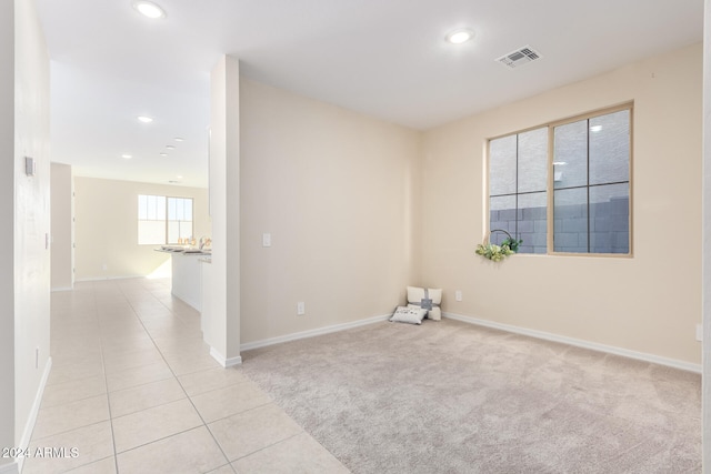 spare room featuring light carpet