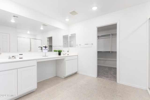 bathroom with tile patterned flooring, vanity, and a shower with shower door