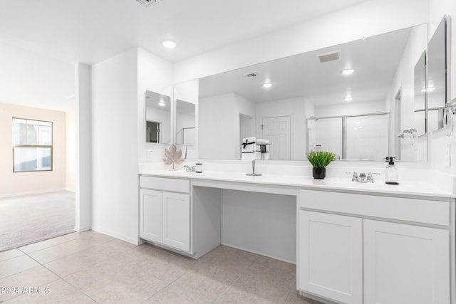 bathroom featuring tile patterned floors, a shower with door, and vanity