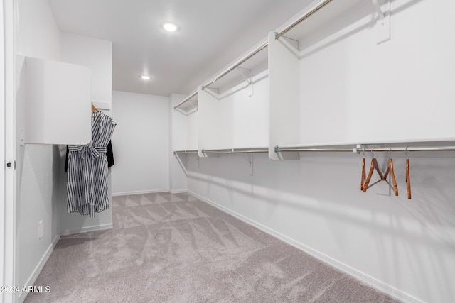 walk in closet featuring light colored carpet