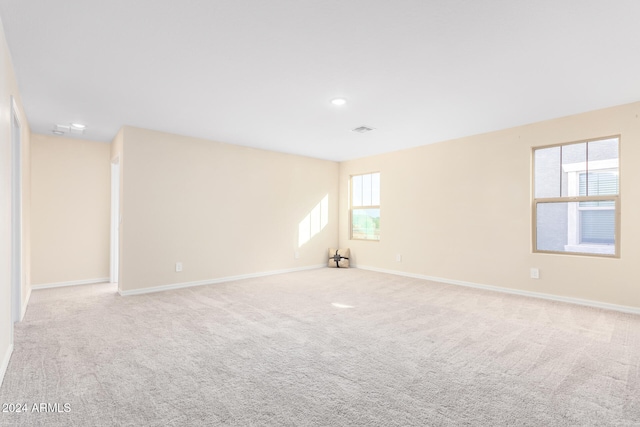 unfurnished room featuring light colored carpet and a healthy amount of sunlight