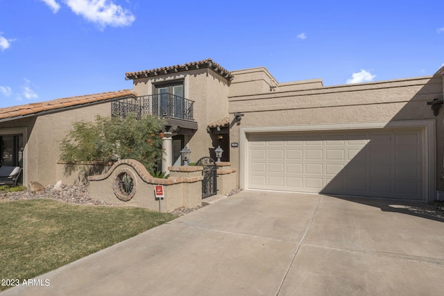 view of front of home with a balcony, a front yard, and a garage