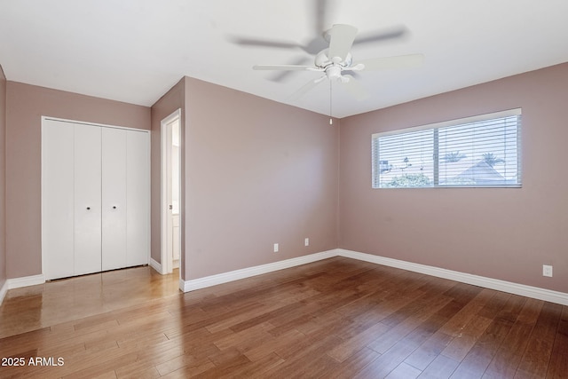 8713 E Sage Dr, Scottsdale, AZ 85250 - unfurnished bedroom featuring hardwood / wood-style floors, baseboards, a closet, and ceiling fan