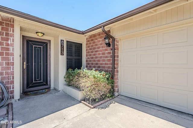 8713 E Sage Dr, Scottsdale, AZ 85250 - view of exterior entry featuring brick siding, driveway, and a garage