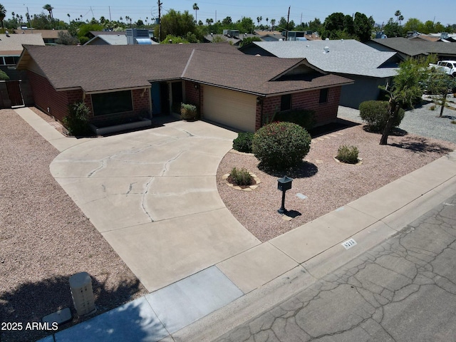 8713 E Sage Dr, Scottsdale, AZ 85250 - view of front of house with brick siding, driveway, an attached garage, and roof with shingles