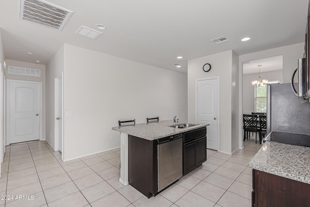 kitchen with stainless steel appliances, a kitchen island with sink, sink, and dark brown cabinets