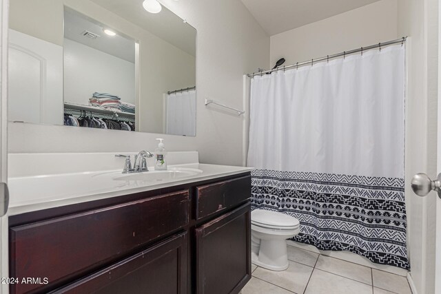 bathroom with vanity, tile patterned flooring, toilet, and curtained shower