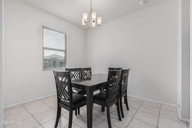 dining space with light tile patterned flooring and an inviting chandelier