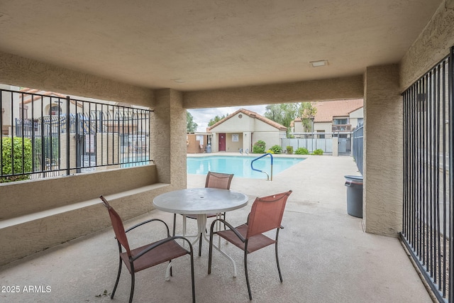 view of patio / terrace featuring a community pool and fence