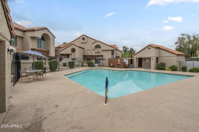 community pool with fence and a patio area