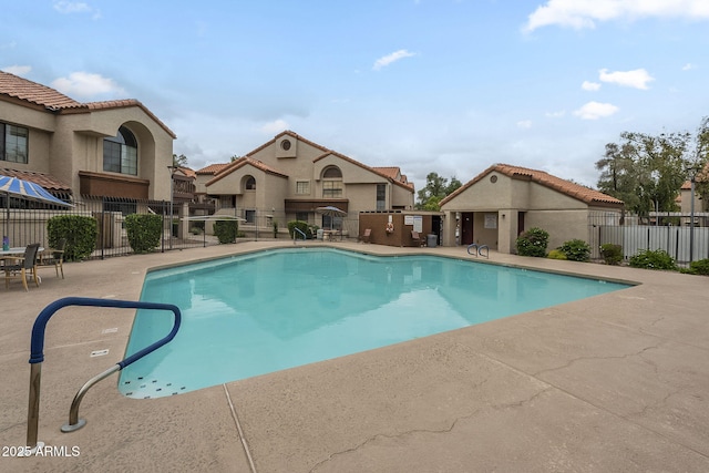 community pool with fence and a patio