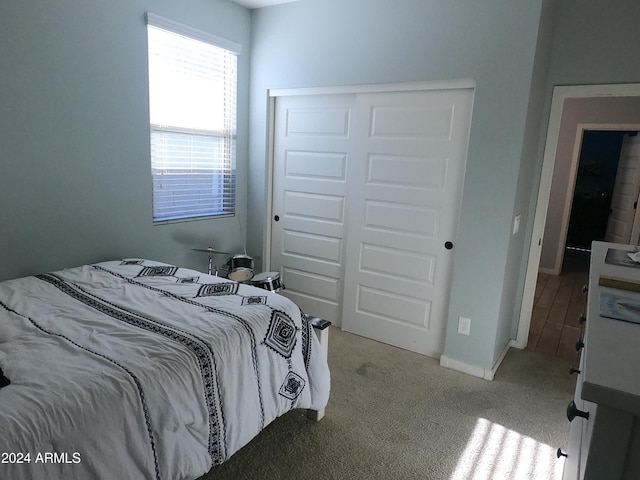 bedroom featuring light carpet and a closet