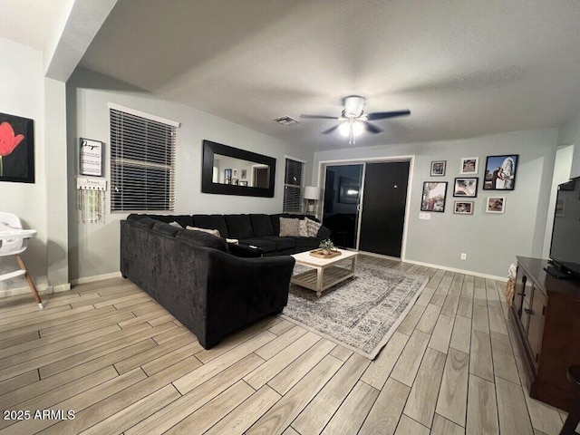 living room featuring a textured ceiling and ceiling fan