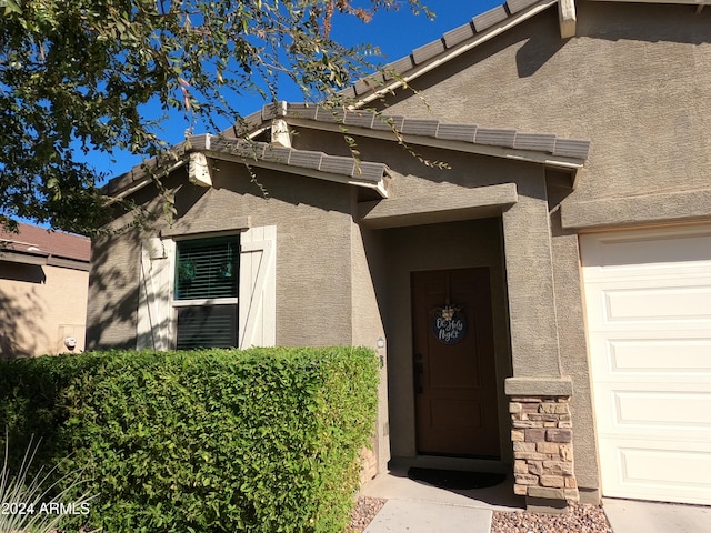 doorway to property with a garage