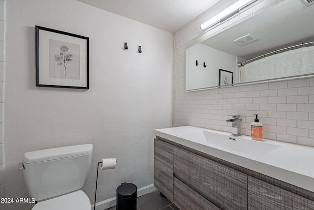 bathroom featuring backsplash, a textured ceiling, vanity, and toilet