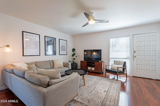 living room featuring ceiling fan and dark wood-type flooring