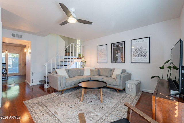 living room featuring ceiling fan and dark wood-type flooring