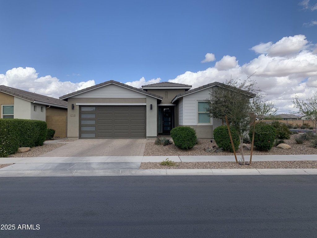 view of front of property featuring a garage, concrete driveway, and stucco siding