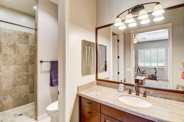 bathroom featuring tiled shower, oversized vanity, and toilet