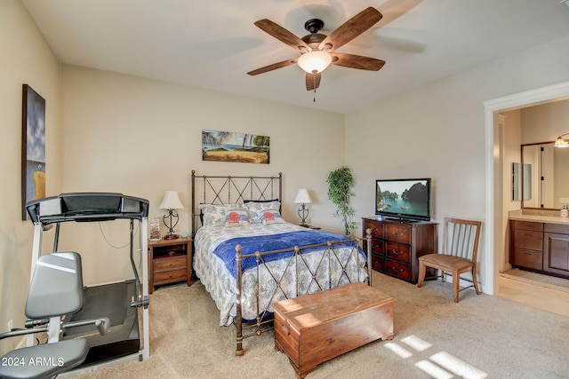 bedroom with light colored carpet, ceiling fan, and ensuite bathroom