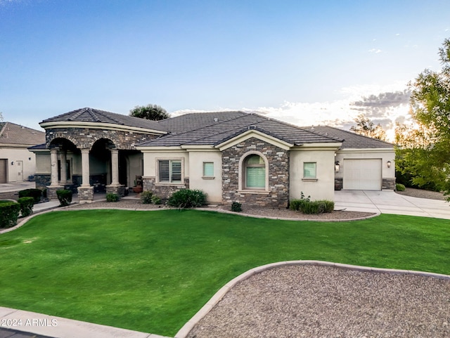 view of front of property with a garage and a lawn