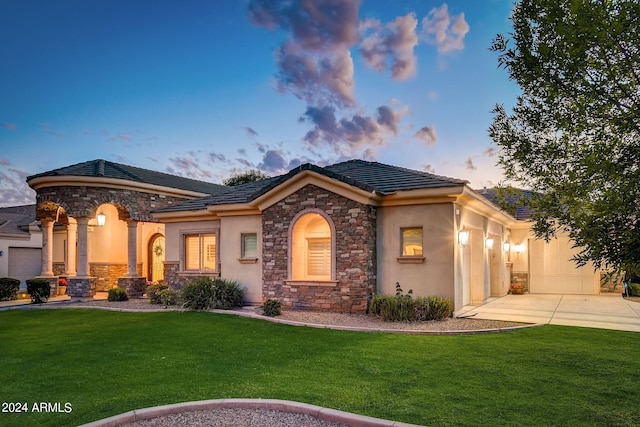 view of front of property featuring a garage and a lawn