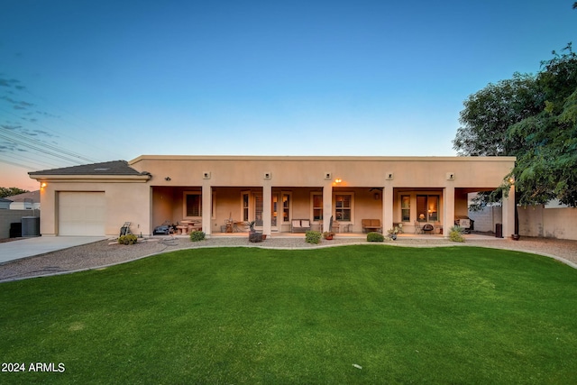 exterior space featuring central AC, a lawn, a garage, and a porch