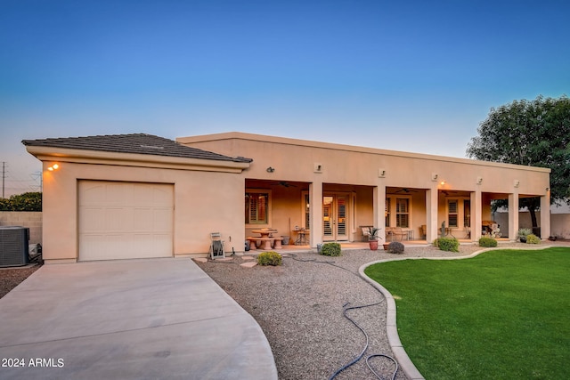 view of front facade featuring a garage, central AC, and a front yard