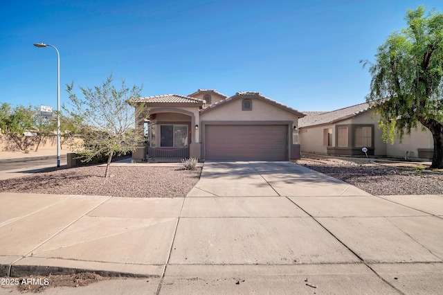 7405 W Elwood St, Phoenix, AZ 85043 - mediterranean / spanish home featuring stucco siding, a garage, concrete driveway, and a tiled roof