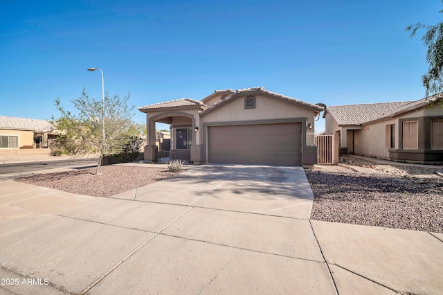 7405 W Elwood St, Phoenix, AZ 85043 - mediterranean / spanish-style house featuring an attached garage, stucco siding, driveway, and a tiled roof
