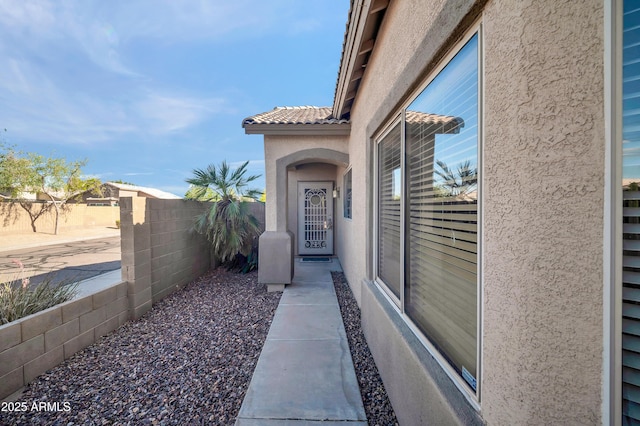 7405 W Elwood St, Phoenix, AZ 85043 - doorway to property with stucco siding, fence, a tile roof, and a patio area