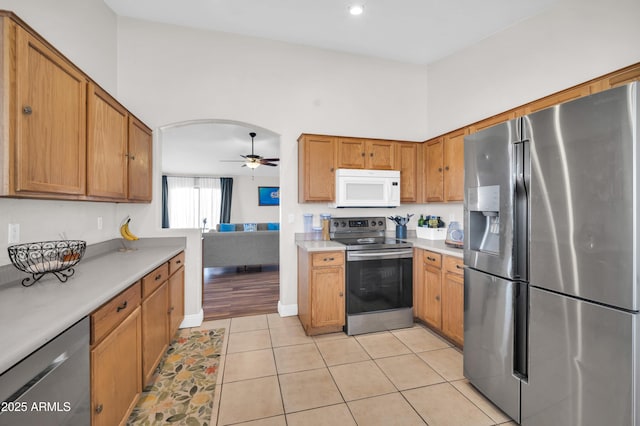 7405 W Elwood St, Phoenix, AZ 85043 - kitchen featuring appliances with stainless steel finishes, ceiling fan, light countertops, brown cabinetry, and light tile patterned flooring