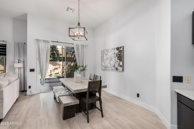 dining area featuring light hardwood / wood-style floors and a chandelier