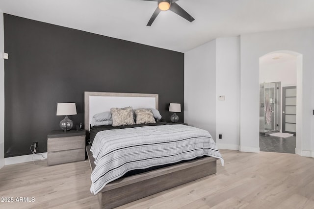 bedroom featuring ensuite bathroom, light wood-type flooring, and ceiling fan