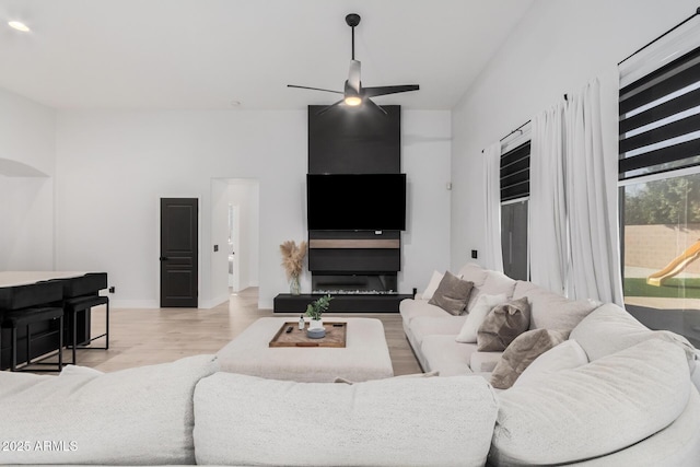 living room featuring ceiling fan and light hardwood / wood-style floors