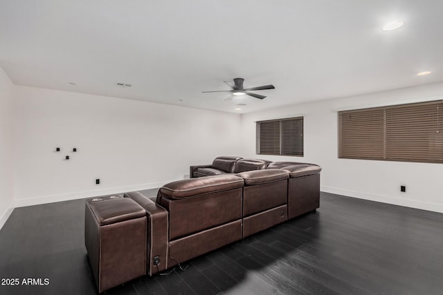 cinema room with ceiling fan and dark hardwood / wood-style flooring