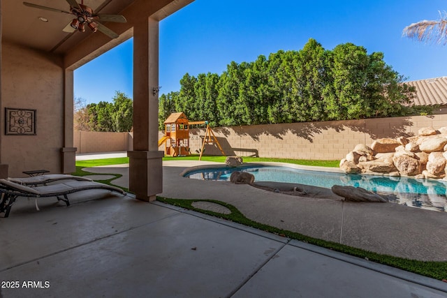 view of pool featuring a playground, a patio, and ceiling fan