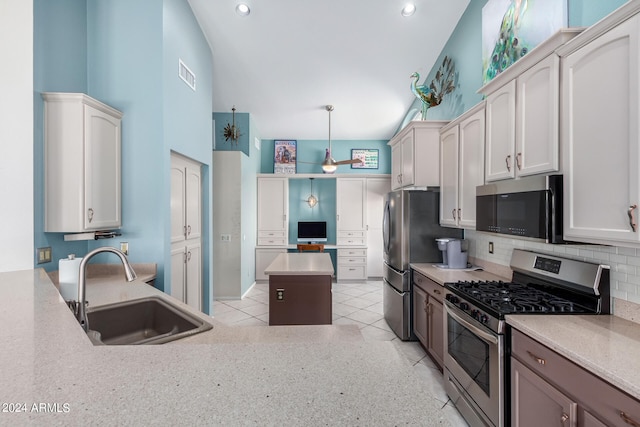 kitchen with hanging light fixtures, sink, white cabinetry, appliances with stainless steel finishes, and decorative backsplash