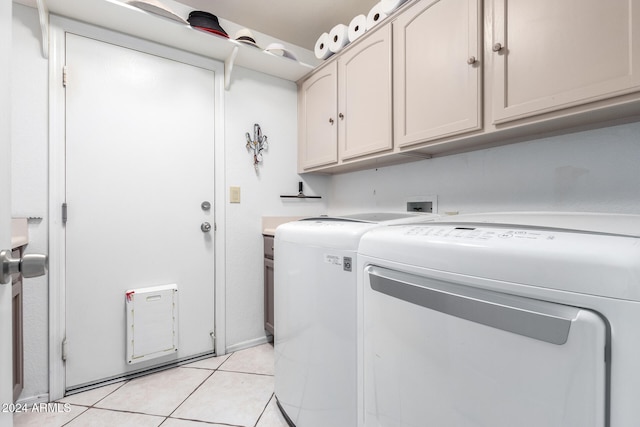 laundry room featuring light tile patterned floors, cabinets, and independent washer and dryer